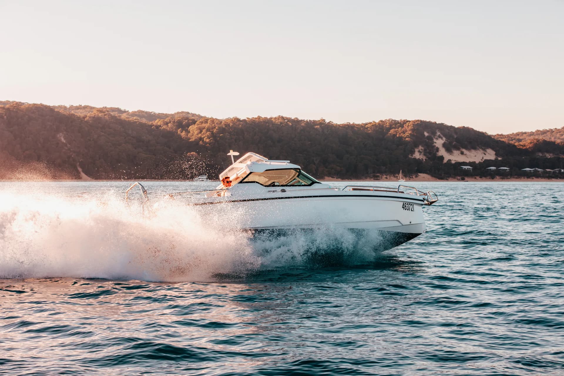Axopar 24 HT running along the Moreton Bay shoreline with sand dunes behind