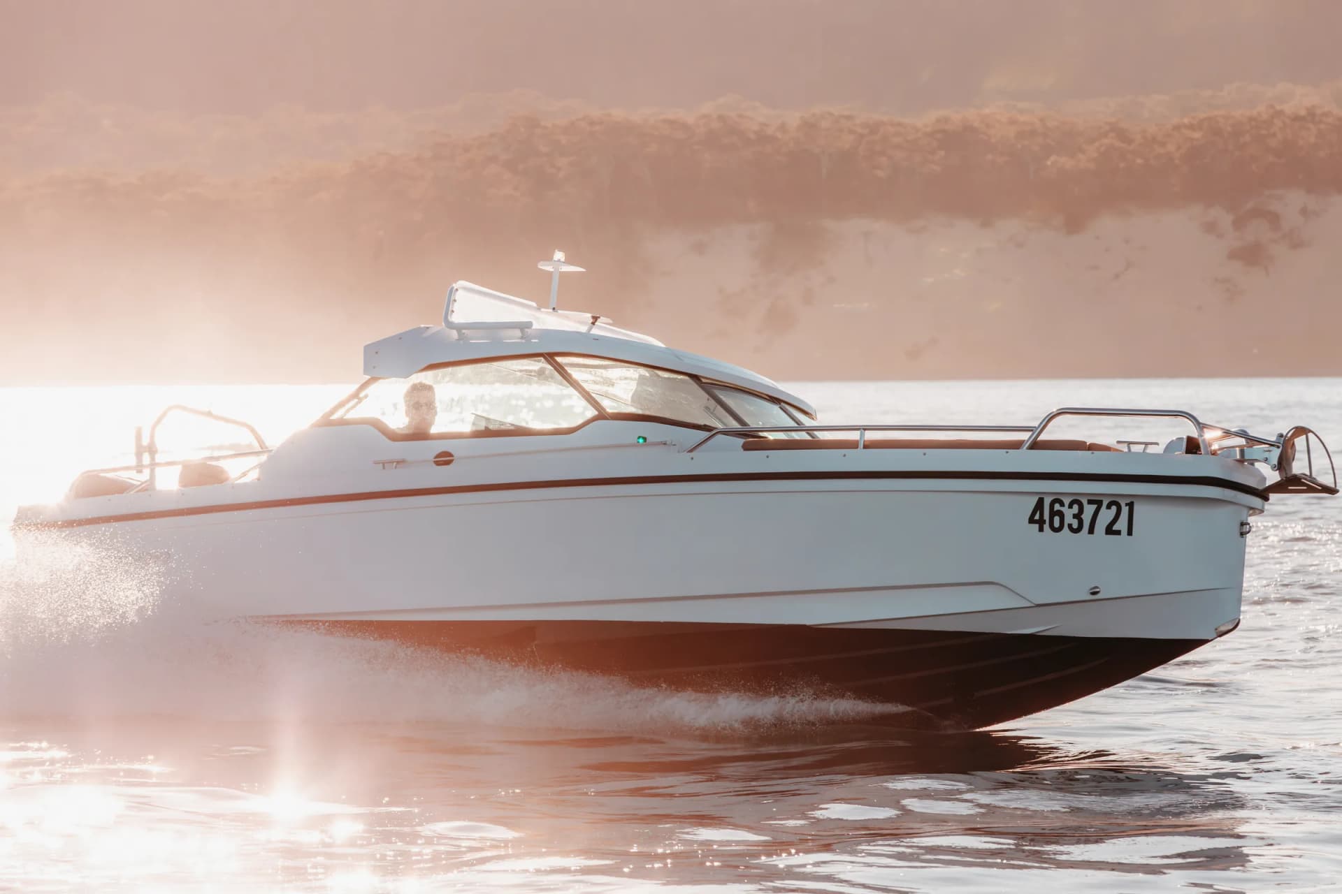 Sea La Vie side on in low golden light on Moreton Bay, hull catching the sun