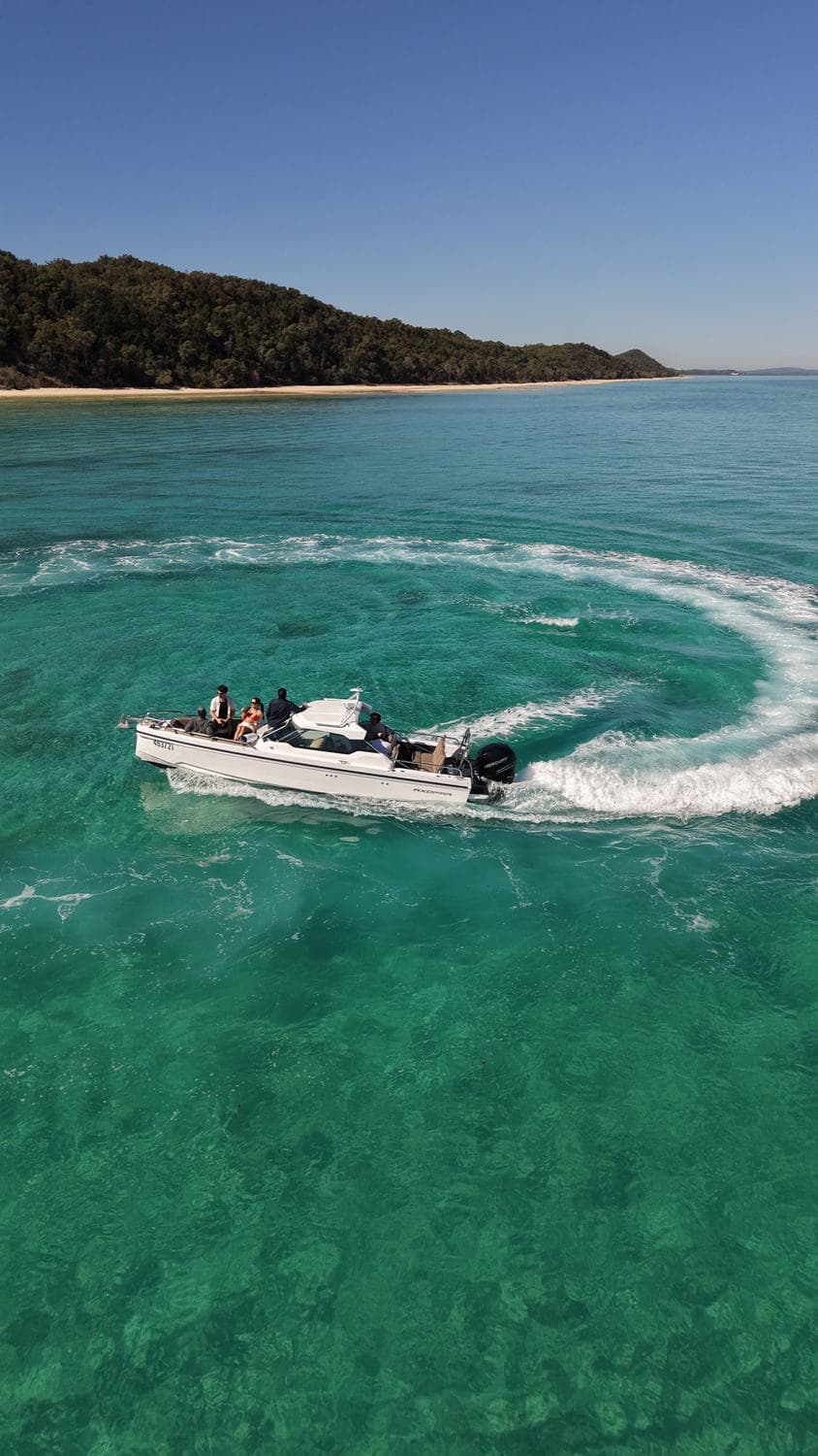 Boats beached in a sparkling cove at Amity with golden sand and clear shallows
