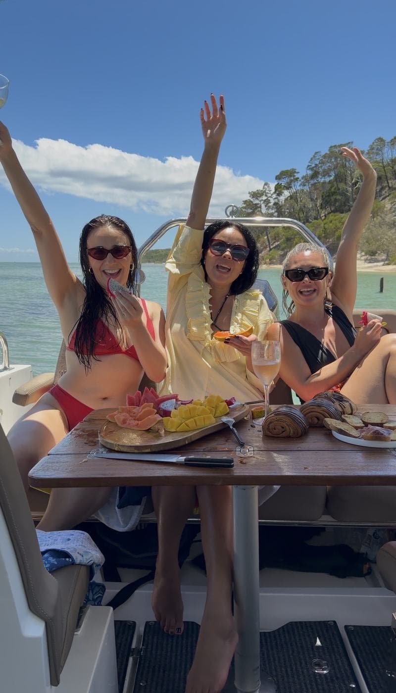 Guests cheering around the cockpit table loaded with a fruit platter and pastries
