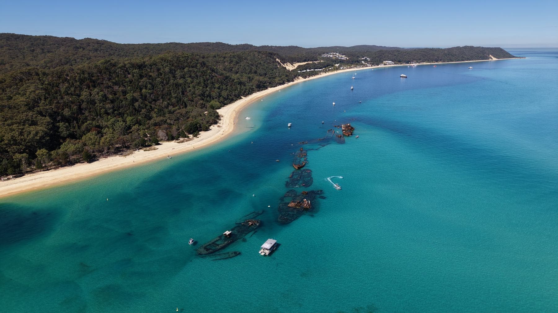 High aerial of the Moreton Island coastline with beach, wreck line and vivid teal shallows