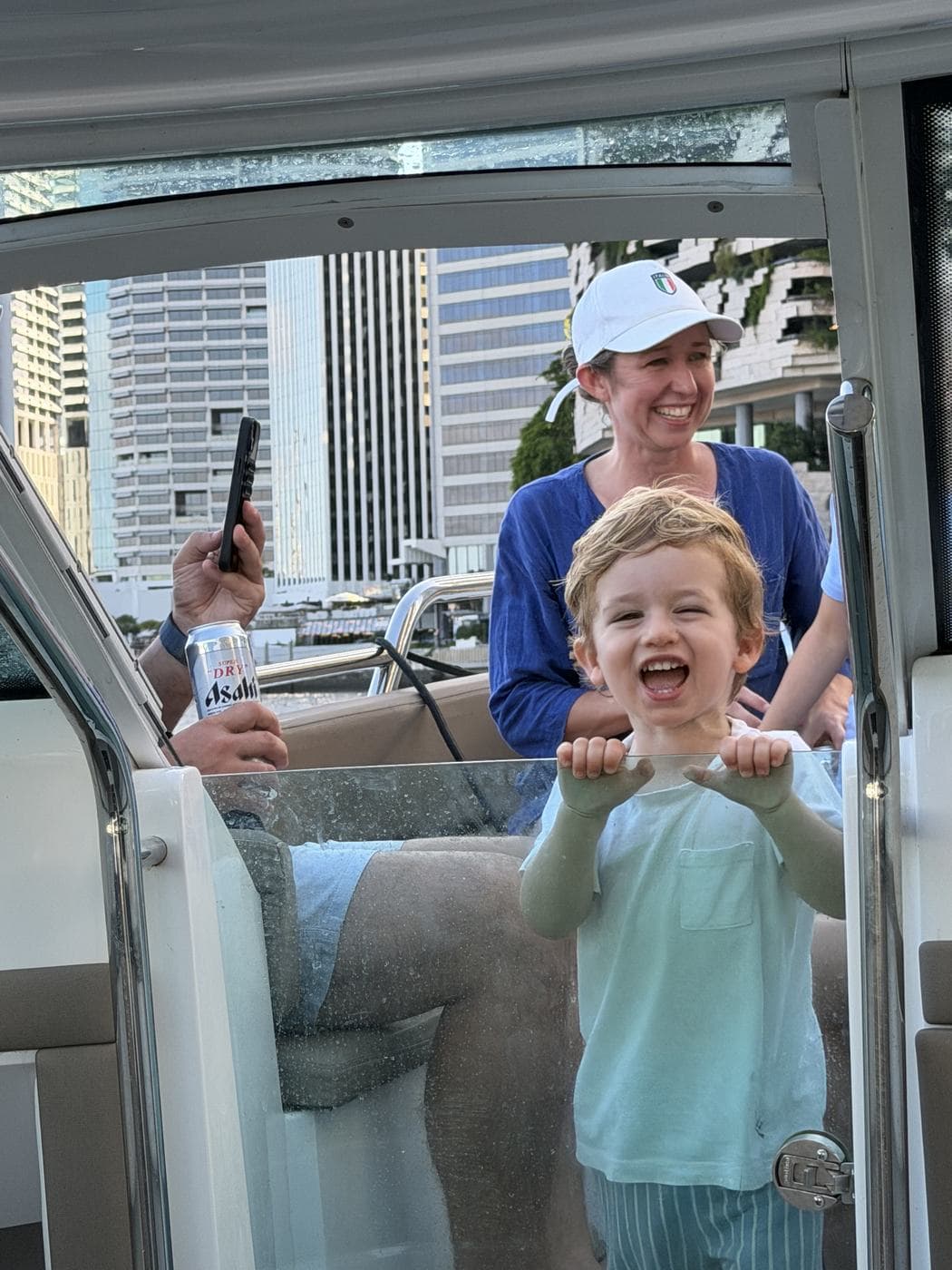 A delighted toddler holding the boat windscreen as the charter cruises the river