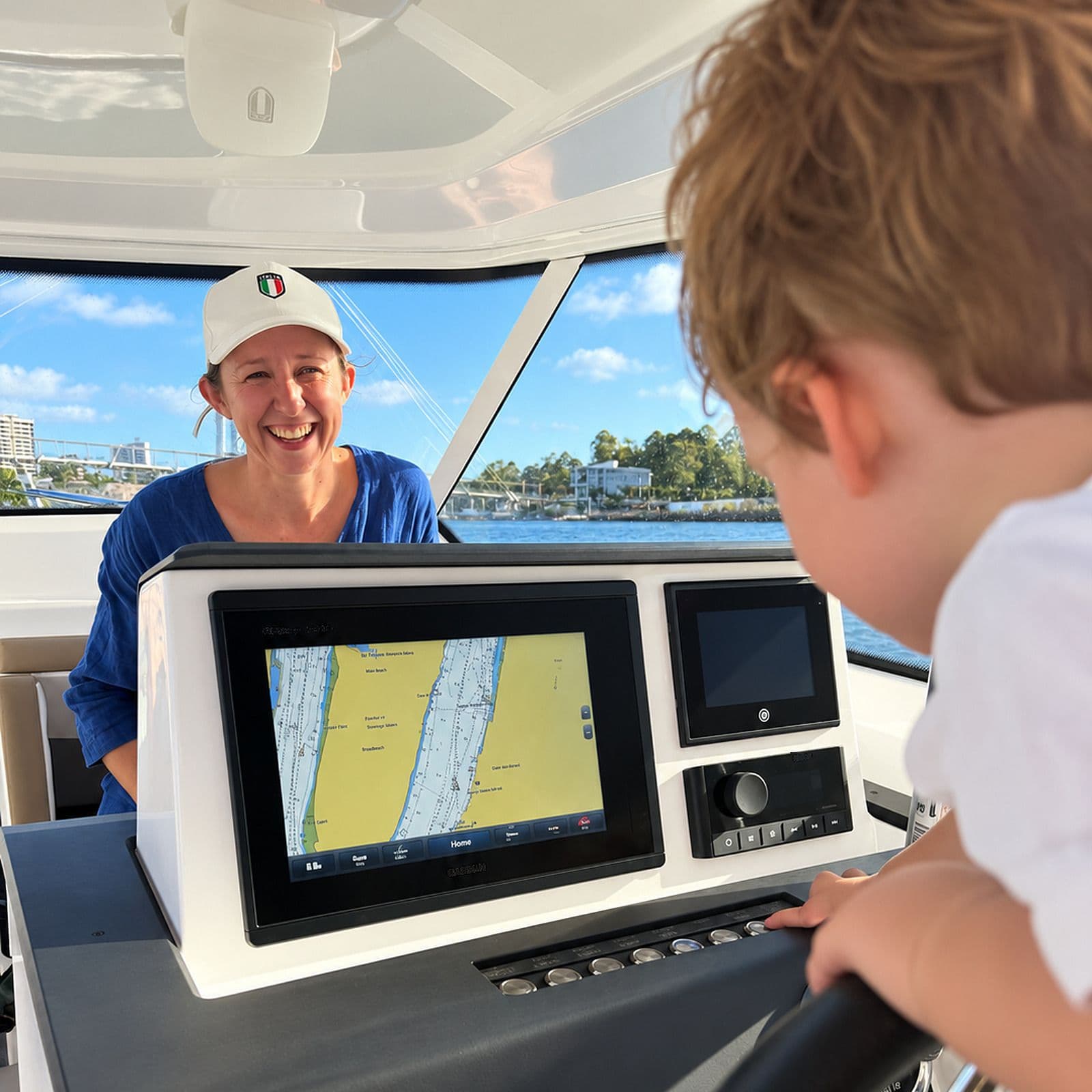 A child at the boat’s wheel with his mother