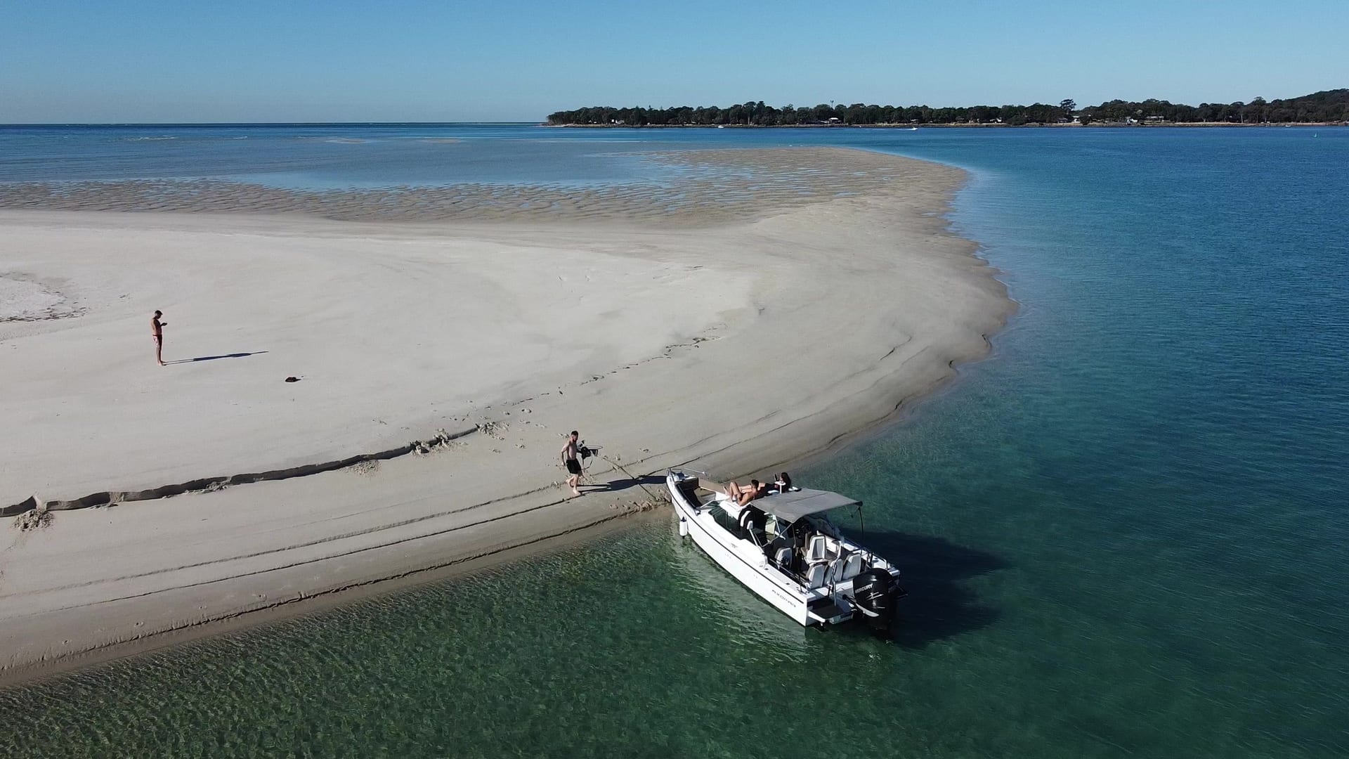 A couple on a private sandbar beside the Sea La Vie boat nosed onto the sand